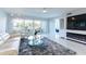 Comfortable living room with water views, sliding glass doors to balcony, and a modern entertainment center at 1365 Snell Isle Ne Blvd # 1B, St Petersburg, FL 33704
