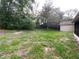 Backyard view of property showing yard with sparse grass and partial shed at 1392 Piper Rd, Spring Hill, FL 34606