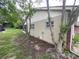 Back exterior view of a home with garden bed area and trees at 1392 Piper Rd, Spring Hill, FL 34606