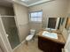 Bathroom with tile floors, vanity with granite counter top, shower, toilet and window at 1392 Piper Rd, Spring Hill, FL 34606