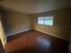 Bedroom showcasing a window and hardwood floors, illuminated by natural light at 1392 Piper Rd, Spring Hill, FL 34606