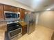 Kitchen featuring stainless steel appliances, tile backsplash, granite countertops and tile flooring at 1392 Piper Rd, Spring Hill, FL 34606
