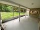 Screened in porch with exterior view of the grassy lawn and wooded area at 1392 Piper Rd, Spring Hill, FL 34606
