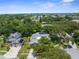 An aerial view showcases a community with solar panels, mature trees, and manicured lawns at 1430 Rosetree Ct, Clearwater, FL 33764