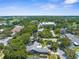 An aerial view of the neighborhood showcasing lush greenery, mature trees, and a mix of residential homes at 1430 Rosetree Ct, Clearwater, FL 33764