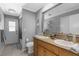 Modern bathroom with double sinks, granite countertop, a shower with glass door and ample lighting at 1430 Rosetree Ct, Clearwater, FL 33764