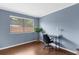 Well-lit bedroom with wood floors, neutral paint, and a desk under the window at 1430 Rosetree Ct, Clearwater, FL 33764