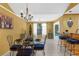 Open dining room with a glass table, wrought iron chairs, and stylish chandelier, leading to kitchen and pool area at 1430 Rosetree Ct, Clearwater, FL 33764