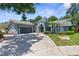 Charming single-story home features a long driveway, two-car garage, and lush landscaping at 1430 Rosetree Ct, Clearwater, FL 33764