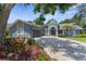 Charming blue single-Gathering home with arched entryway, well-manicured landscaping, and a spacious driveway at 1430 Rosetree Ct, Clearwater, FL 33764