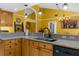 Well-lit kitchen with granite countertops, an island sink, and modern black appliances at 1430 Rosetree Ct, Clearwater, FL 33764