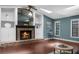 Cozy living room with a brick fireplace, built-in shelves, skylights, and hardwood floors at 1430 Rosetree Ct, Clearwater, FL 33764
