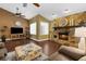 Cozy living room with stone fireplace, wood floors, and a ceiling fan for added comfort at 1430 Rosetree Ct, Clearwater, FL 33764