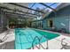 Beautiful backyard boasts a spacious screened-in pool with plenty of room for seating and lounging at 1430 Rosetree Ct, Clearwater, FL 33764