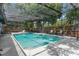 Relaxing backyard with a screened-in pool, mature trees, and ample seating for outdoor enjoyment at 1430 Rosetree Ct, Clearwater, FL 33764