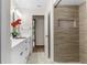 Bright bathroom featuring a double vanity, white cabinets, tiled shower, and modern fixtures at 14645 Spellman Ct, Spring Hill, FL 34610