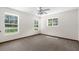 Bright bedroom featuring neutral carpet, ample windows, and a modern ceiling fan at 14645 Spellman Ct, Spring Hill, FL 34610