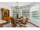 Bright dining area with large windows, tan chairs, and view of the screened-in pool at 14645 Spellman Ct, Spring Hill, FL 34610