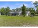Back exterior view showcasing the screened-in pool and lush backyard at 14645 Spellman Ct, Spring Hill, FL 34610