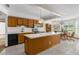Bright eat-in kitchen features wood cabinets, an island, and stainless appliances at 14645 Spellman Ct, Spring Hill, FL 34610