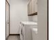 Bright laundry area featuring modern washer and dryer, and convenient overhead storage cabinets at 14645 Spellman Ct, Spring Hill, FL 34610