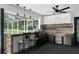 Outdoor kitchen offering counter seating, stainless appliances, and cabinets under a ceiling fan at 14645 Spellman Ct, Spring Hill, FL 34610