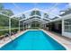 A screened-in pool with brick pavers and outdoor living area is perfect for entertaining guests at 14645 Spellman Ct, Spring Hill, FL 34610