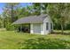 A shed with garage door offers additional storage with an attached covered area at 14645 Spellman Ct, Spring Hill, FL 34610