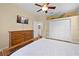 Bright bedroom with a ceiling fan, closet, dresser, and a view of the bathroom at 15004 Middle Fairway Dr, Spring Hill, FL 34609