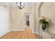 Inviting entryway featuring wood floors, neutral walls, and elegant light fixture at 15004 Middle Fairway Dr, Spring Hill, FL 34609