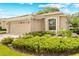 Charming home exterior featuring a well-maintained lawn, lush landscaping, and a two-car garage at 15004 Middle Fairway Dr, Spring Hill, FL 34609