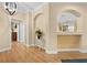Bright foyer featuring wood flooring, arched doorways, and a decorative foyer table at 15004 Middle Fairway Dr, Spring Hill, FL 34609