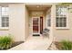 Welcoming front porch with a bench, glass storm door and well-maintained landscaping at 15004 Middle Fairway Dr, Spring Hill, FL 34609