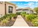 Beautiful walkway to front door with lush landscaping and a charming stone dog statue at 15004 Middle Fairway Dr, Spring Hill, FL 34609