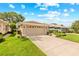 A home with a spacious two-car garage and an extended driveway, surrounded by green lawns at 15004 Middle Fairway Dr, Spring Hill, FL 34609