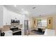 Eat-in kitchen area with stainless appliances, breakfast bar, white cabinets, and wood flooring at 15004 Middle Fairway Dr, Spring Hill, FL 34609