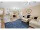 Bright living room with a blue rug, cream-colored furniture and wood flooring at 15004 Middle Fairway Dr, Spring Hill, FL 34609