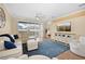 Spacious living room with hardwood floors, white sectional sofa, and large sliding glass doors at 15004 Middle Fairway Dr, Spring Hill, FL 34609