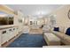 Open-concept living room featuring wood floors, cream furniture, and a large blue area rug at 15004 Middle Fairway Dr, Spring Hill, FL 34609