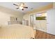 Bright main bedroom featuring wood floors, a ceiling fan, and a wall-mounted TV at 15004 Middle Fairway Dr, Spring Hill, FL 34609
