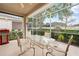 Relaxing screened patio with outdoor dining set and view of the backyard at 15004 Middle Fairway Dr, Spring Hill, FL 34609