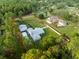 Aerial view of the property featuring a long driveway, white fencing and mature tree growth at 15430 Oakcrest Cir, Brooksville, FL 34604
