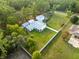 Aerial view of home surrounded by trees, a large yard, and a white fence at 15430 Oakcrest Cir, Brooksville, FL 34604