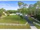 Aerial shot of gorgeous home, garages, long driveway, white perimeter fence and beautiful lawn at 15430 Oakcrest Cir, Brooksville, FL 34604