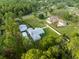 Aerial view showcasing a house with large property, surrounding trees, and a long driveway at 15430 Oakcrest Cir, Brooksville, FL 34604