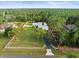 Aerial shot outlining the property with a white fence, green lawn, and a long driveway at 15430 Oakcrest Cir, Brooksville, FL 34604