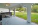 Covered back porch with hot tub, ceiling fan, and view of the backyard at 15430 Oakcrest Cir, Brooksville, FL 34604