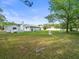 Lush backyard showcasing a well-maintained lawn and a charming white bench at 15430 Oakcrest Cir, Brooksville, FL 34604