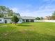 Well-manicured backyard featuring green grass and an inviting patio space at 15430 Oakcrest Cir, Brooksville, FL 34604