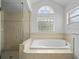 Bright bathroom features a large soaking tub and glass-enclosed shower at 15430 Oakcrest Cir, Brooksville, FL 34604